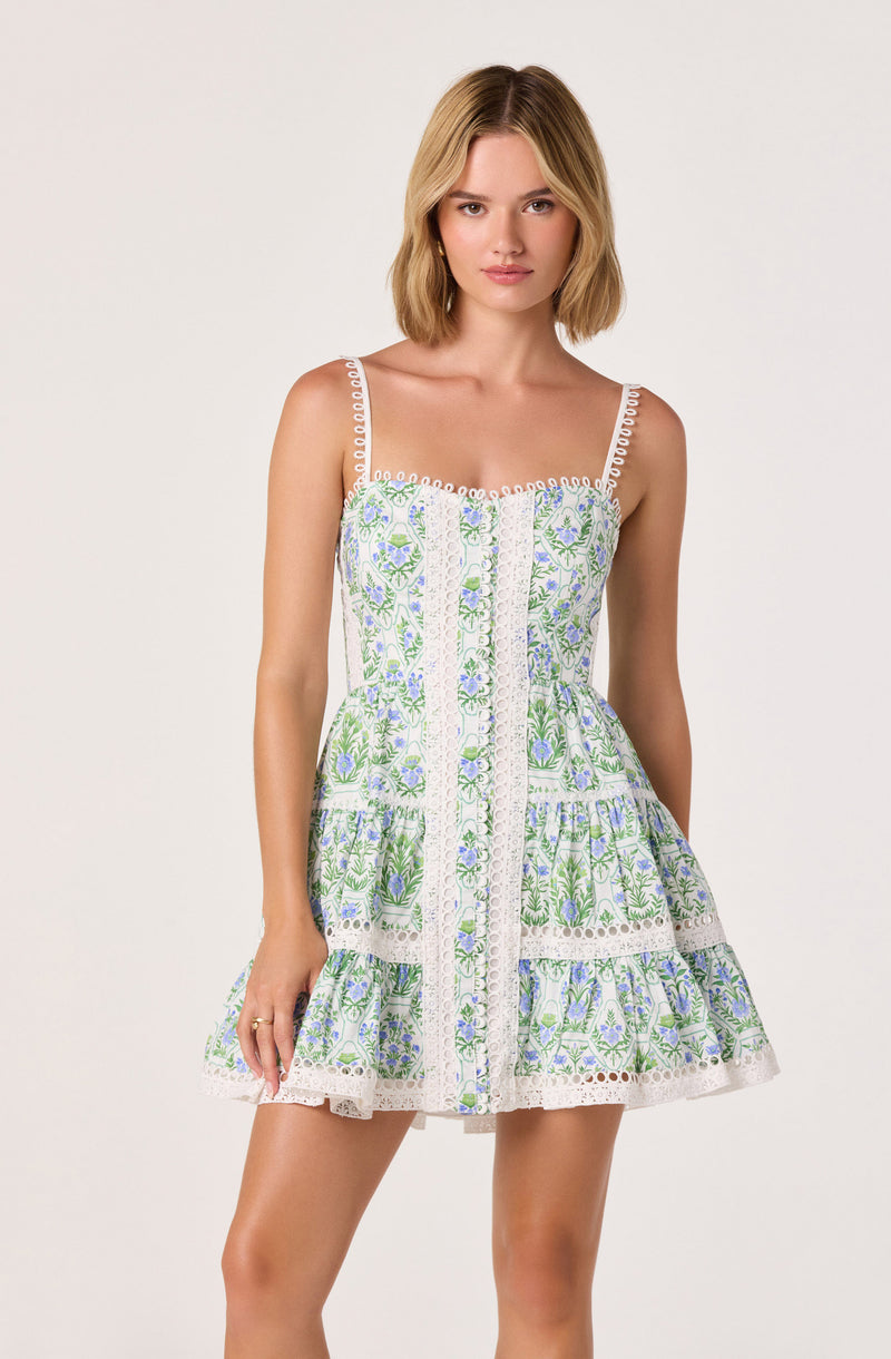 Sleeveless dress with adjustable straps, white with green and purple floral embroidery, tiered ruffle skirt.