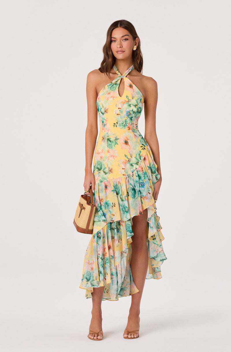 Woman in a yellow floral halter dress with ruffled asymmetrical hem.
