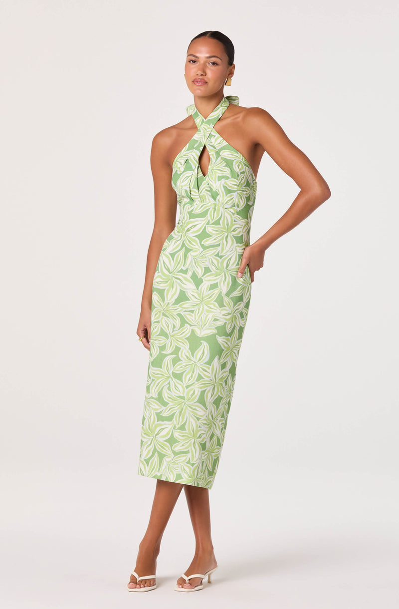 Woman wearing a green and white floral halter neck dress with a keyhole cutout.