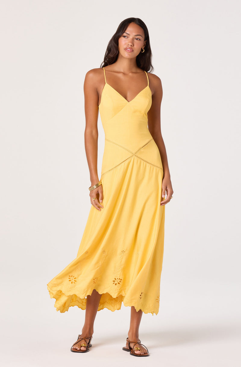 Yellow sleeveless dress with thin straps, fitted bodice, and embroidered hem.