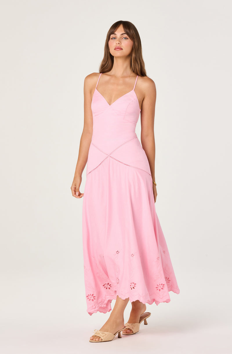 Light pink spaghetti strap maxi dress with embroidered floral hem and cutout details.