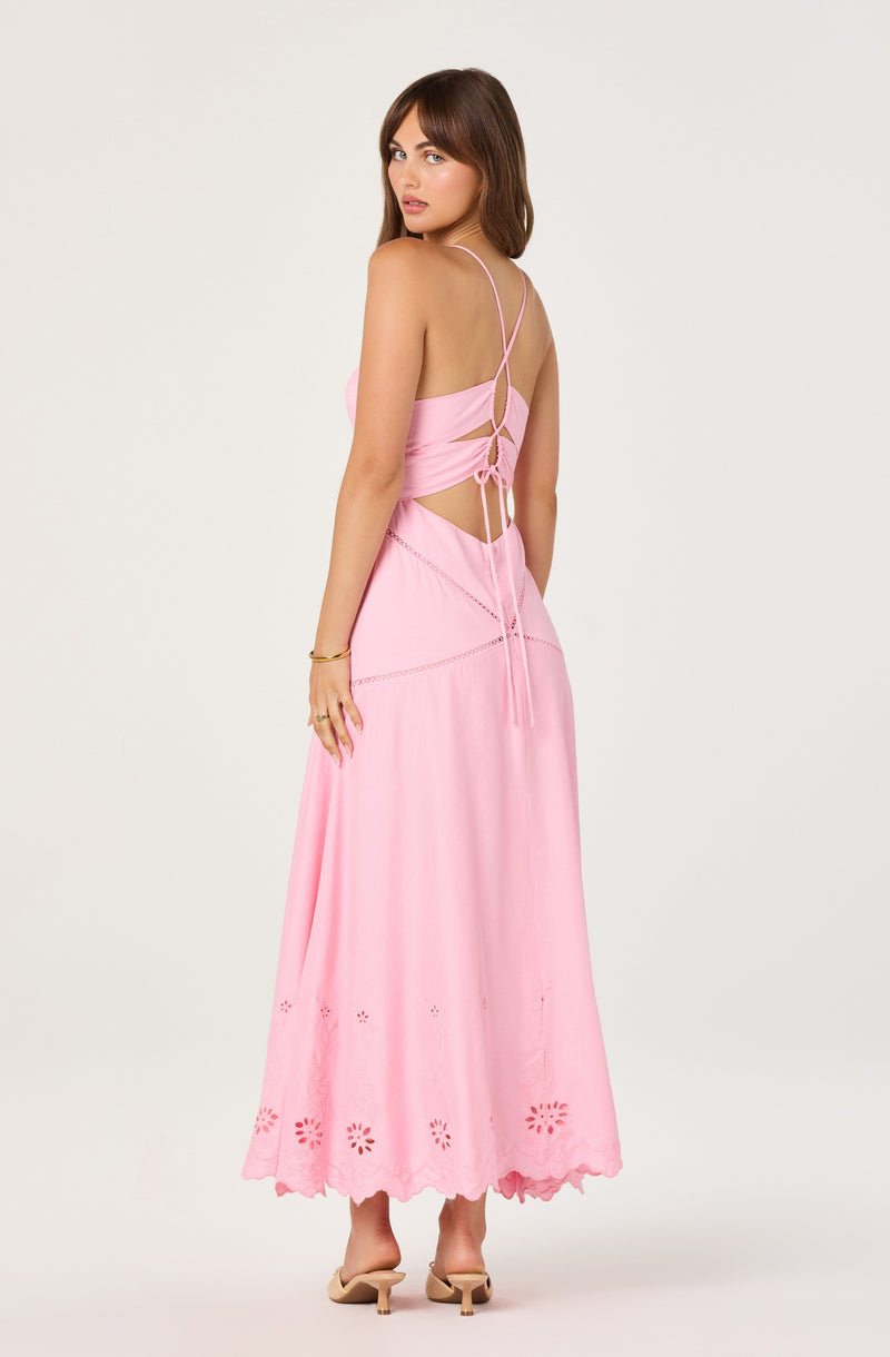 Woman in pink cut-out maxi dress with spaghetti straps and lace-up back.