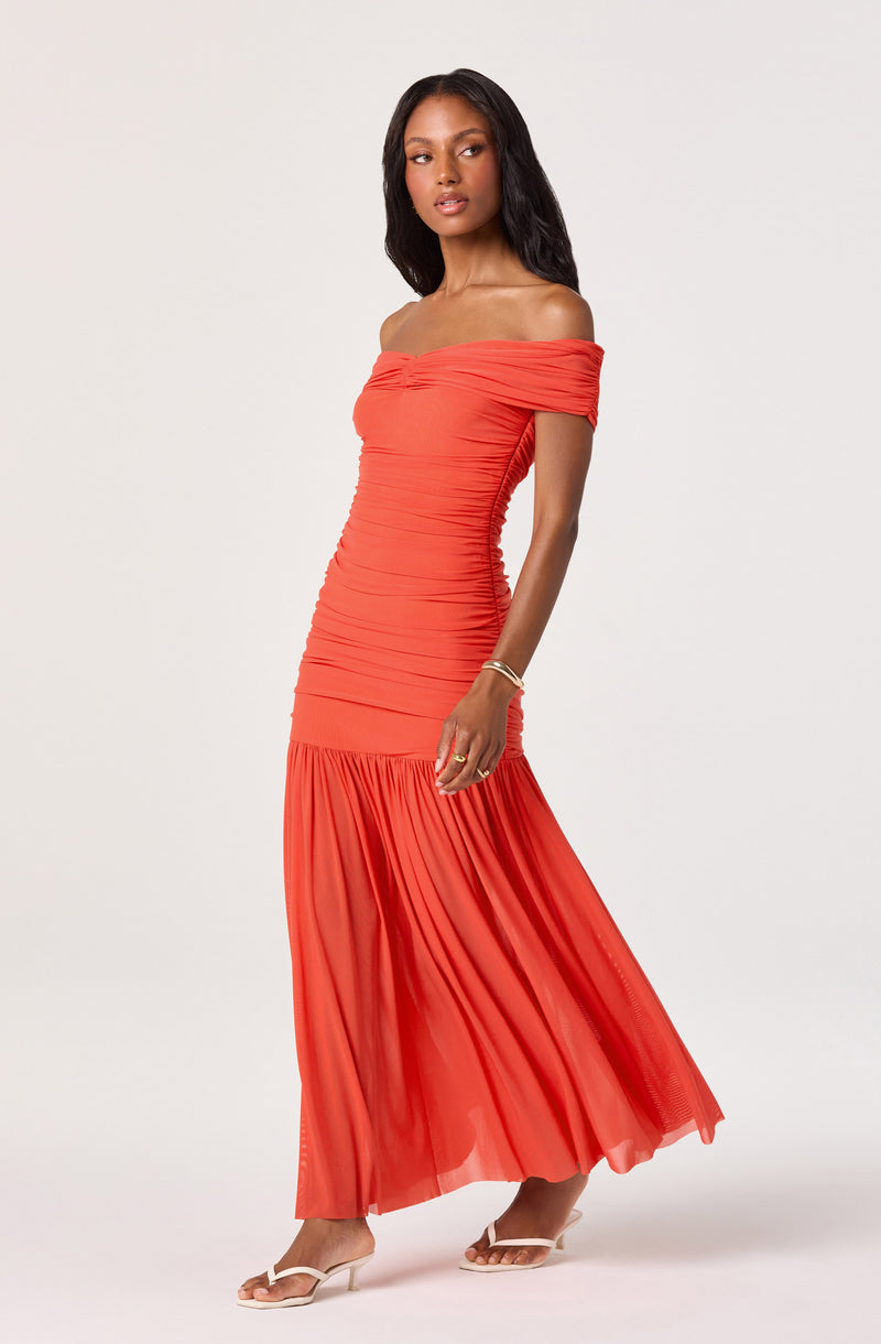 Off-the-shoulder coral dress with ruched bodice and pleated skirt.