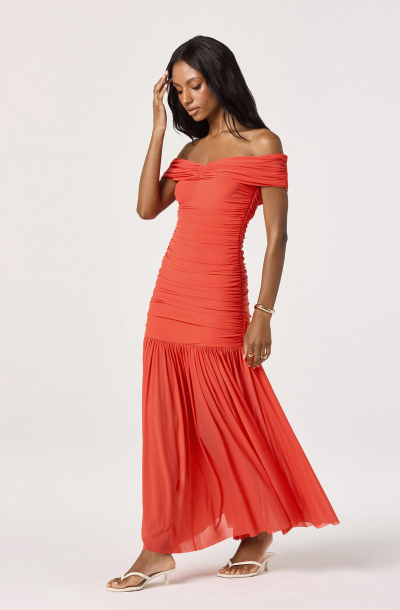 Off-shoulder coral maxi dress with ruched bodice and pleated skirt.