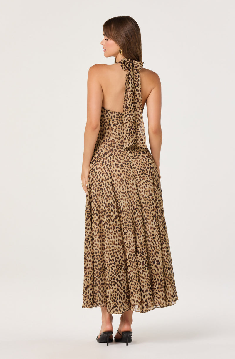 Woman in a sleeveless, backless leopard print dress with a tied bow at the neck.