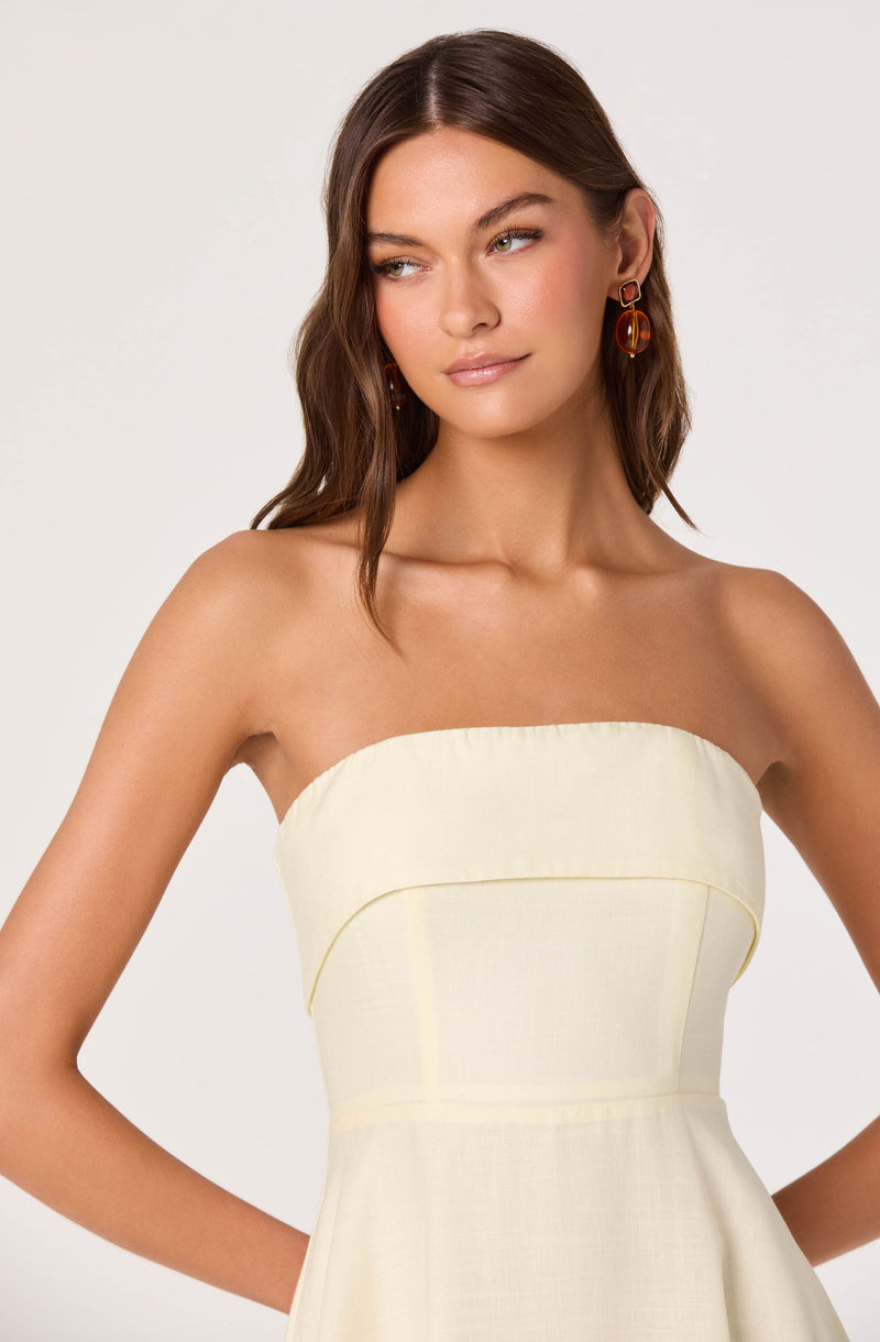Cream strapless dress with a fitted bodice and subtle stitching details.