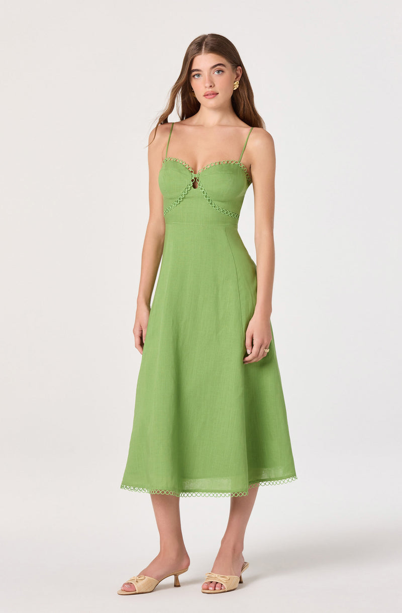 Woman in a lime green sundress with spaghetti straps and decorative trim, paired with beige open-toe heels.
