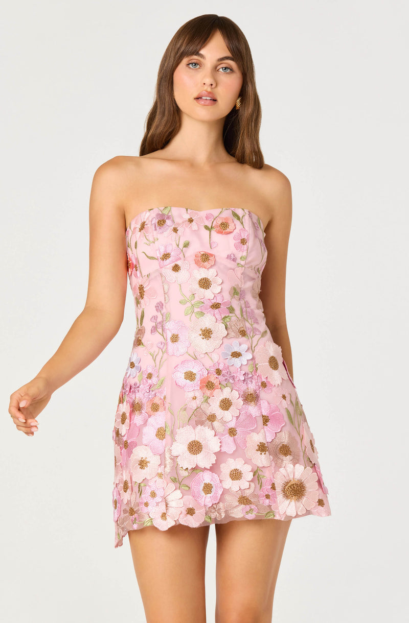 Woman in pink strapless dress with floral embroidery below the waist.