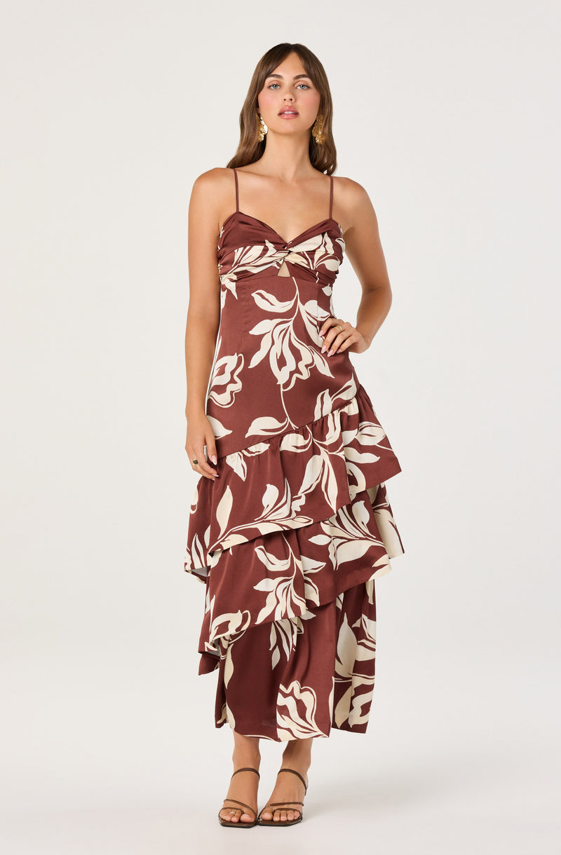 Woman wearing a brown and cream floral layered dress with spaghetti straps.
