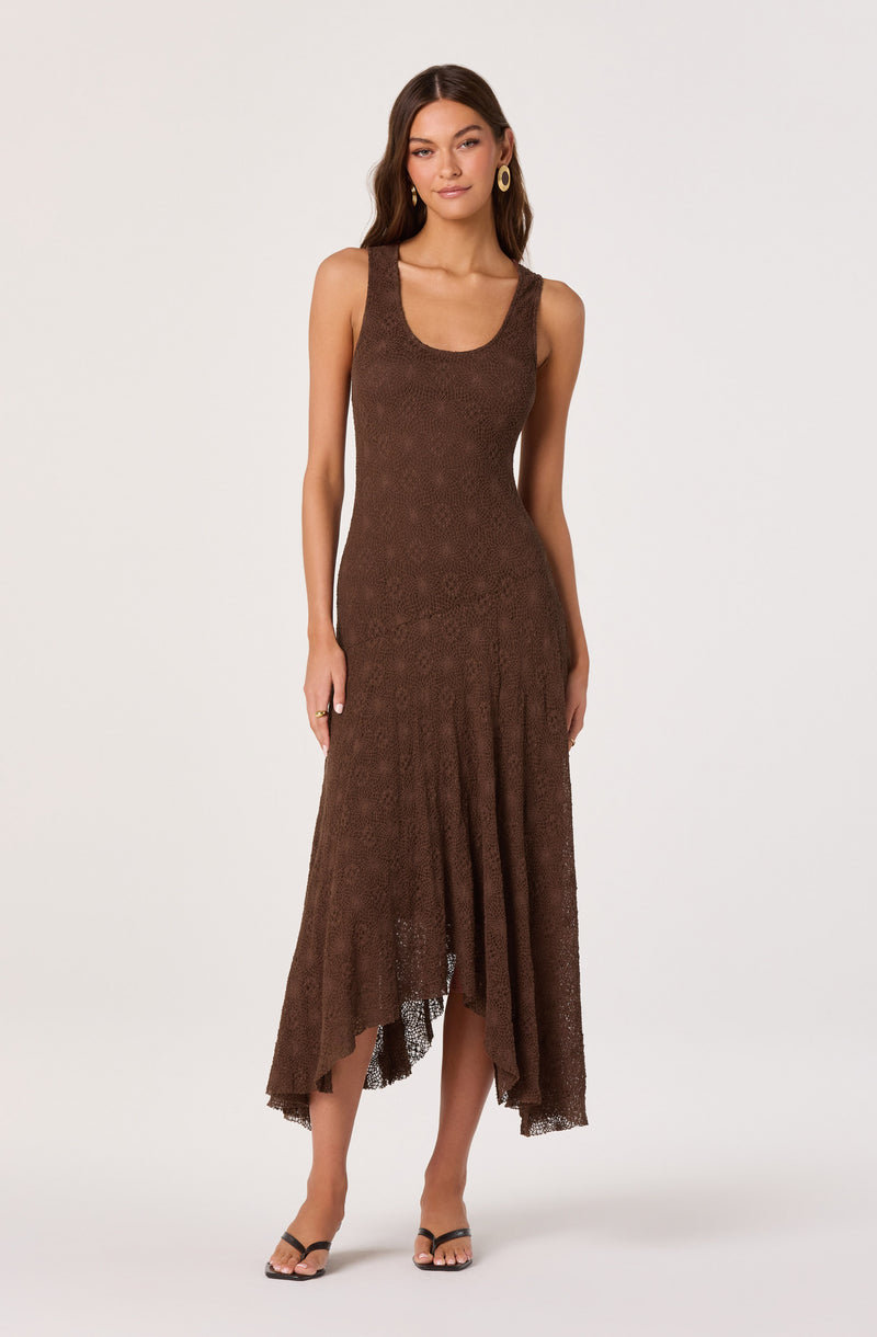 Woman wearing a sleeveless brown lace dress with a scoop neckline and an asymmetrical hem.