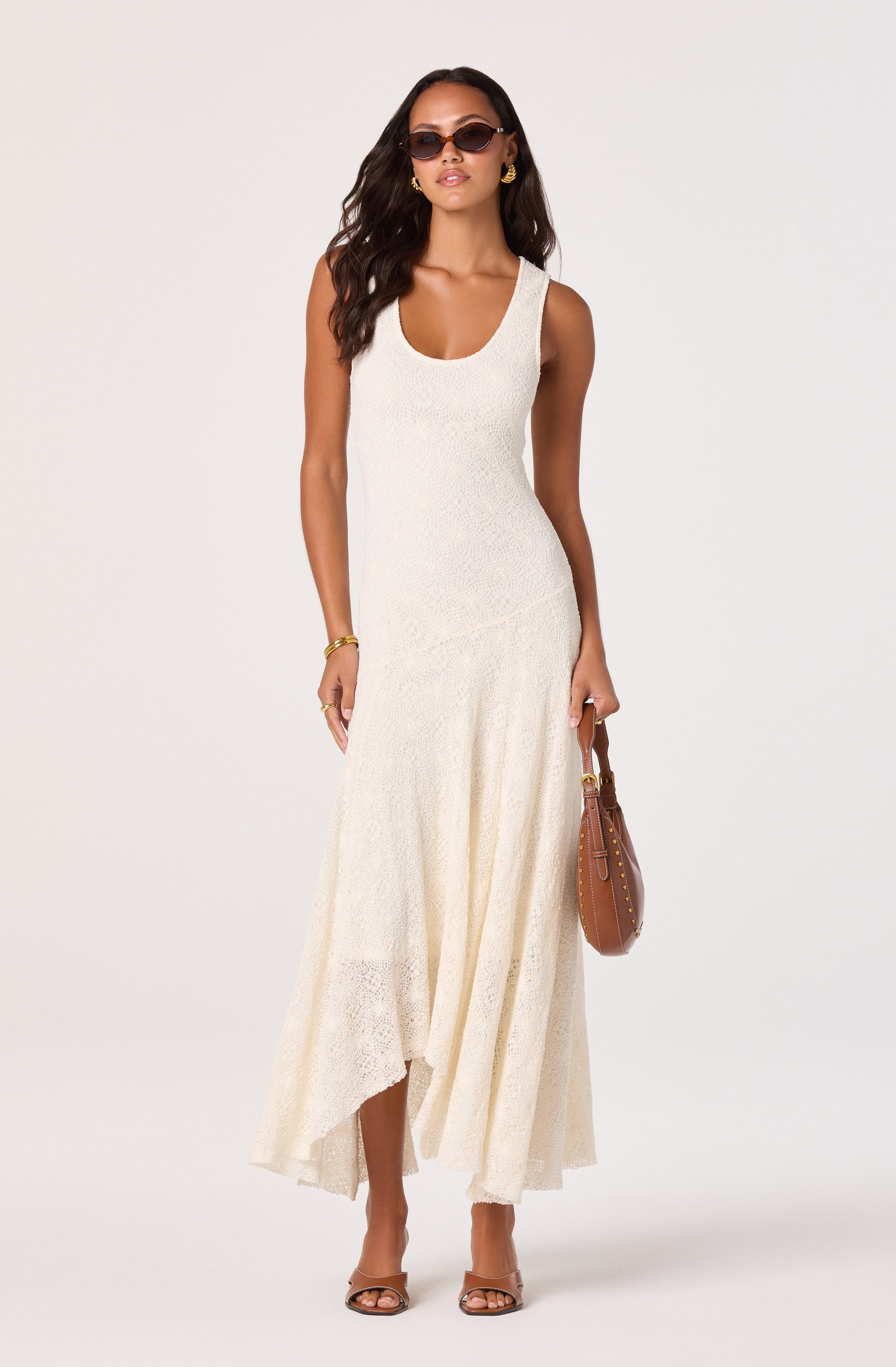 Woman in a long, cream-colored sleeveless dress with a textured fabric.