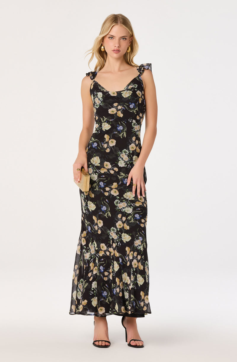 Long black floral dress with ruffled shoulder straps, fitted waist, and a slit at the hem.