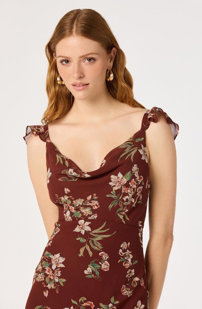 Woman wearing a brown floral dress with ruffled shoulder straps.