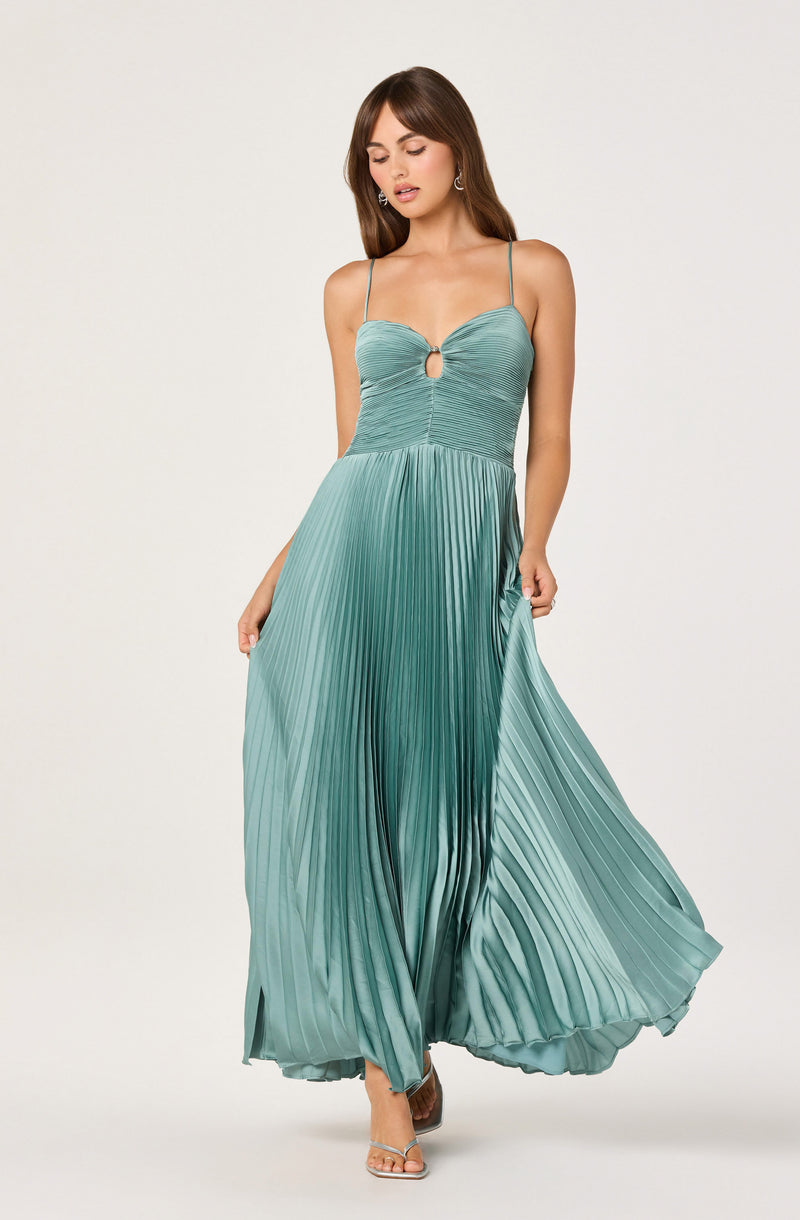 A woman wears a teal pleated maxi dress with a ruched bodice, spaghetti straps, and a front keyhole detail.