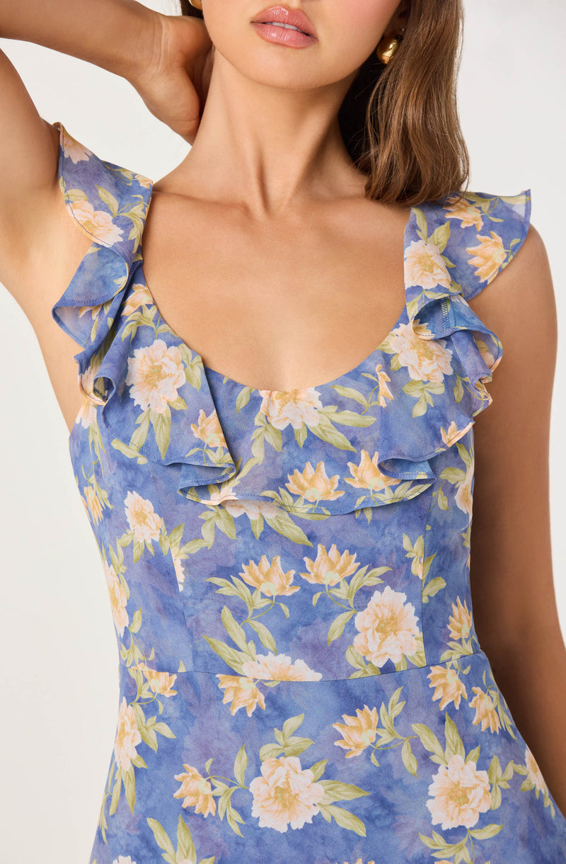 Women wearing a blue floral dress with ruffled sleeves and a scoop neckline.