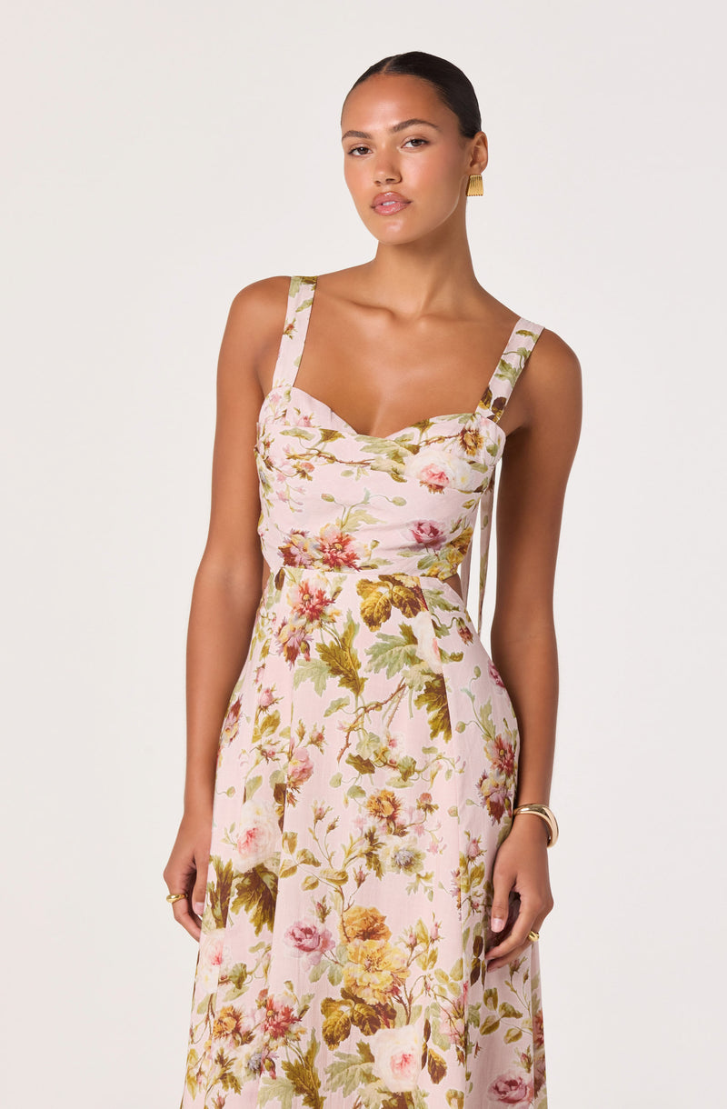 Woman in a pink floral dress with wide straps and a fitted bodice.