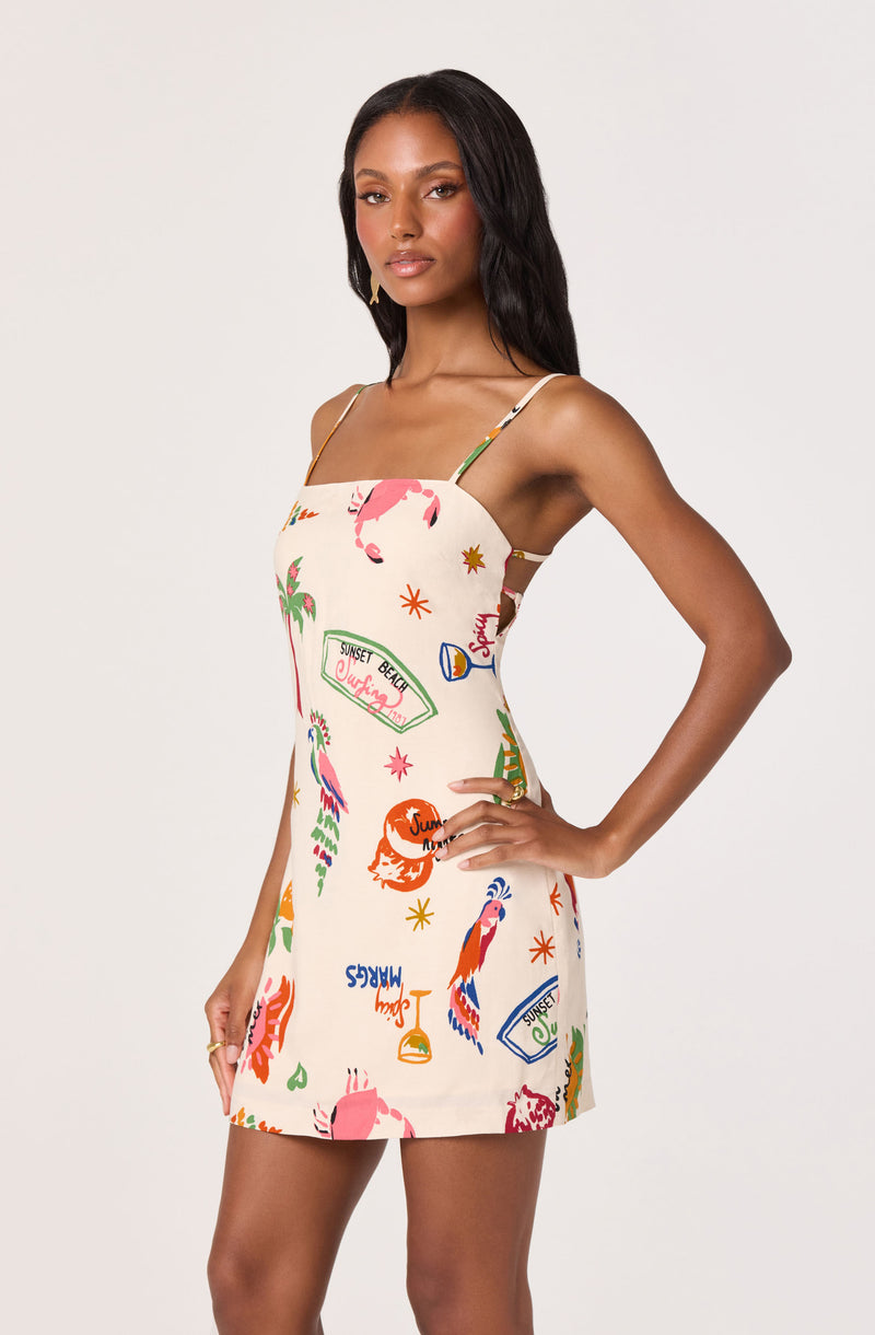 Sleeveless dress with colorful tropical and summer-themed prints on a white background.