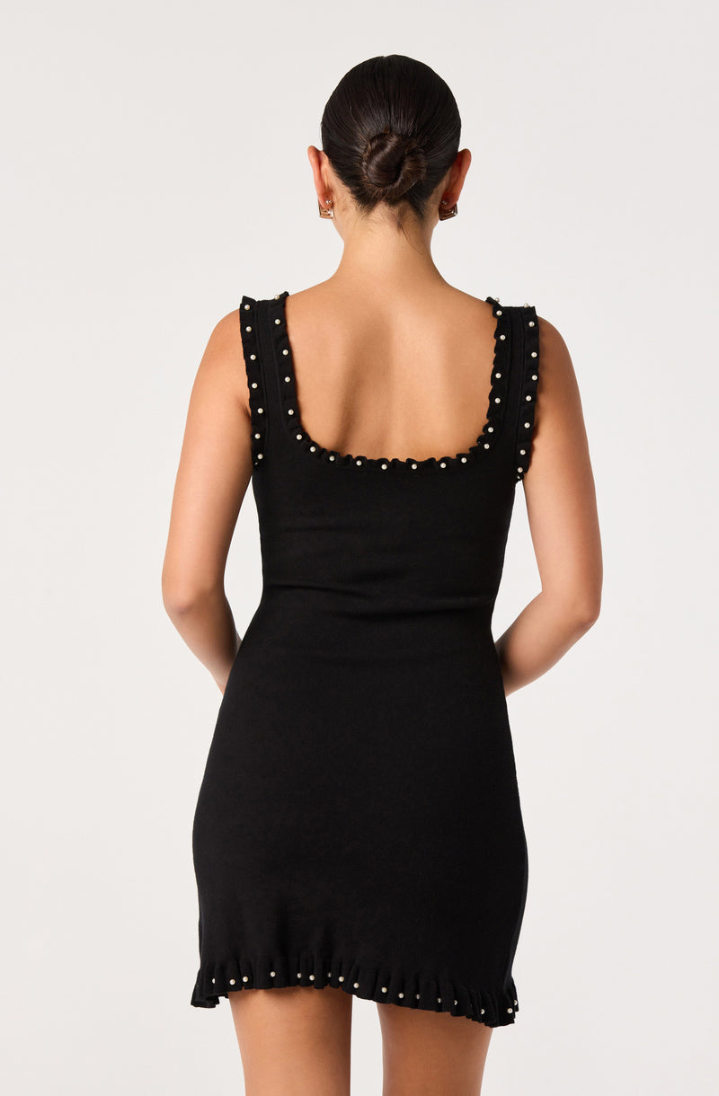 Black sleeveless dress with pearl embellishments on the straps, neckline, and hem.