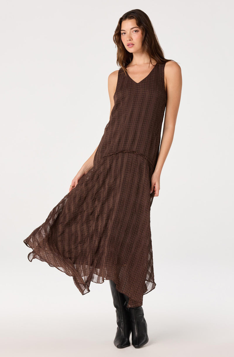 Brown sleeveless dress with vertical stripe pattern and sheer, flowing fabric.
