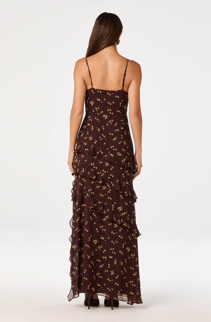 Woman wearing a brown floral spaghetti strap dress with ruffled tiers.