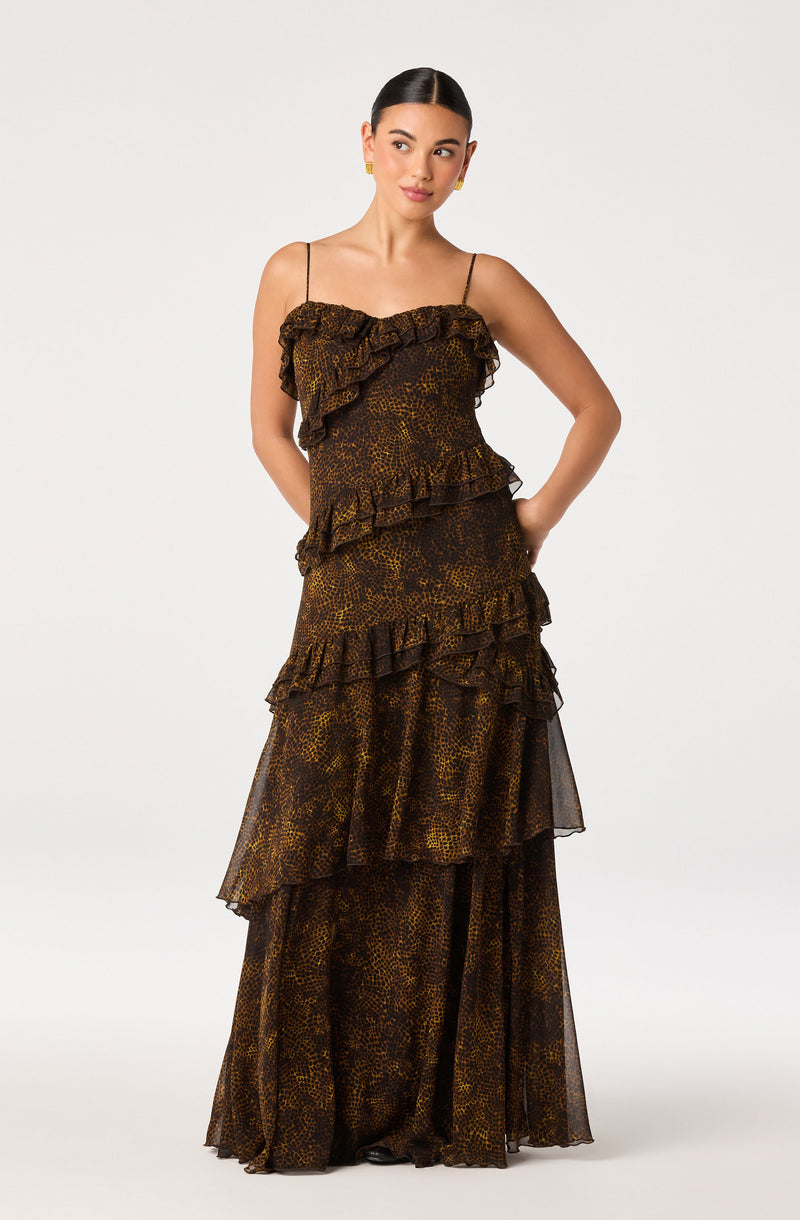Woman in a long, tiered, animal print dress with ruffles and spaghetti straps.