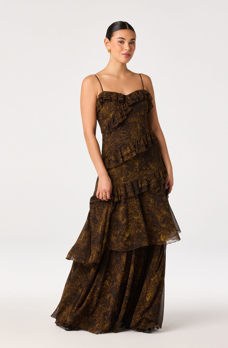 Woman wearing a sleeveless, animal print dress with ruffles and sheer, wide-leg pants.