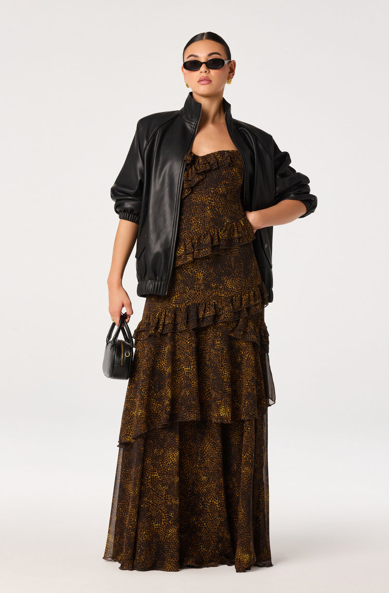 Woman wearing a leopard-print tiered dress with a black leather jacket and sunglasses.