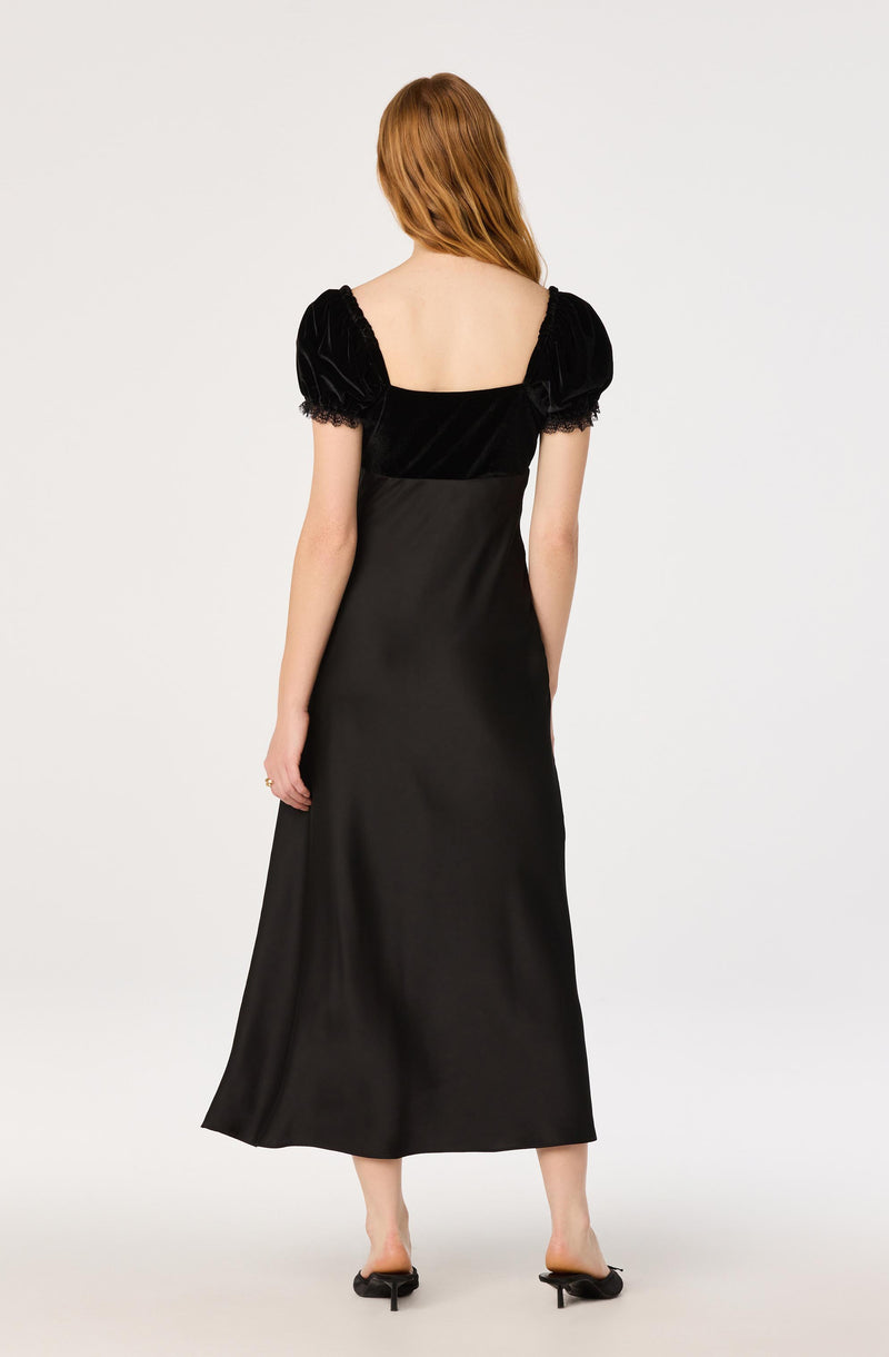 Black velvet dress with puffed short sleeves and a square neckline.