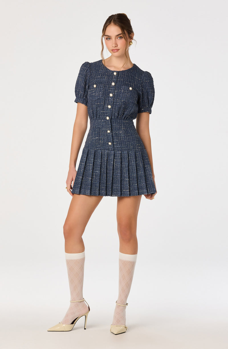 Blue textured dress with pearl buttons, puff sleeves, and a pleated skirt.