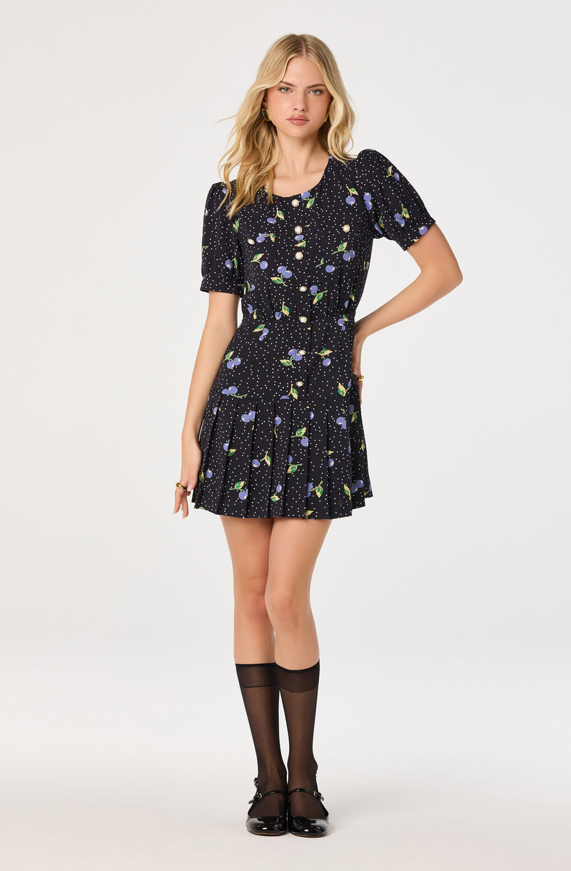 Black dress with a colorful floral and polka dot pattern, short puffed sleeves, and a fitted waist.