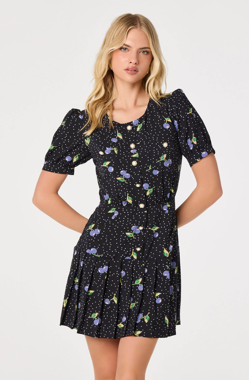 Black dress with a floral and polka dot pattern, puff sleeves, and pleated skirt.