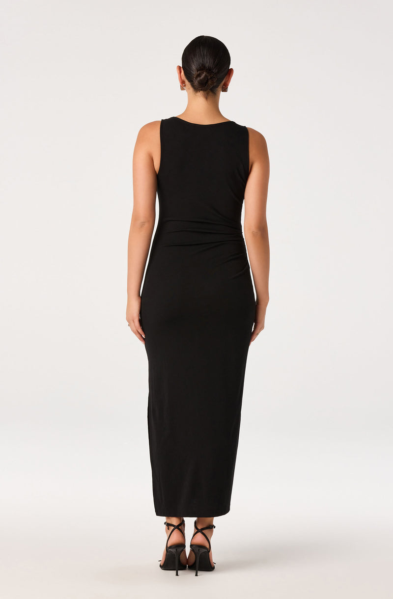 Woman in a long, sleeveless black dress with high heels, seen from behind.
