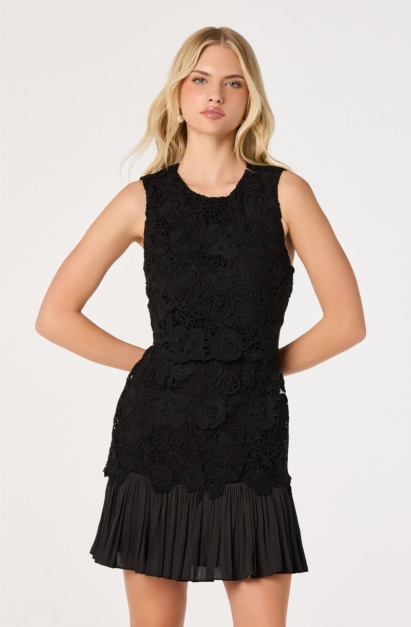 Black sleeveless dress with lace floral top and a pleated skirt.