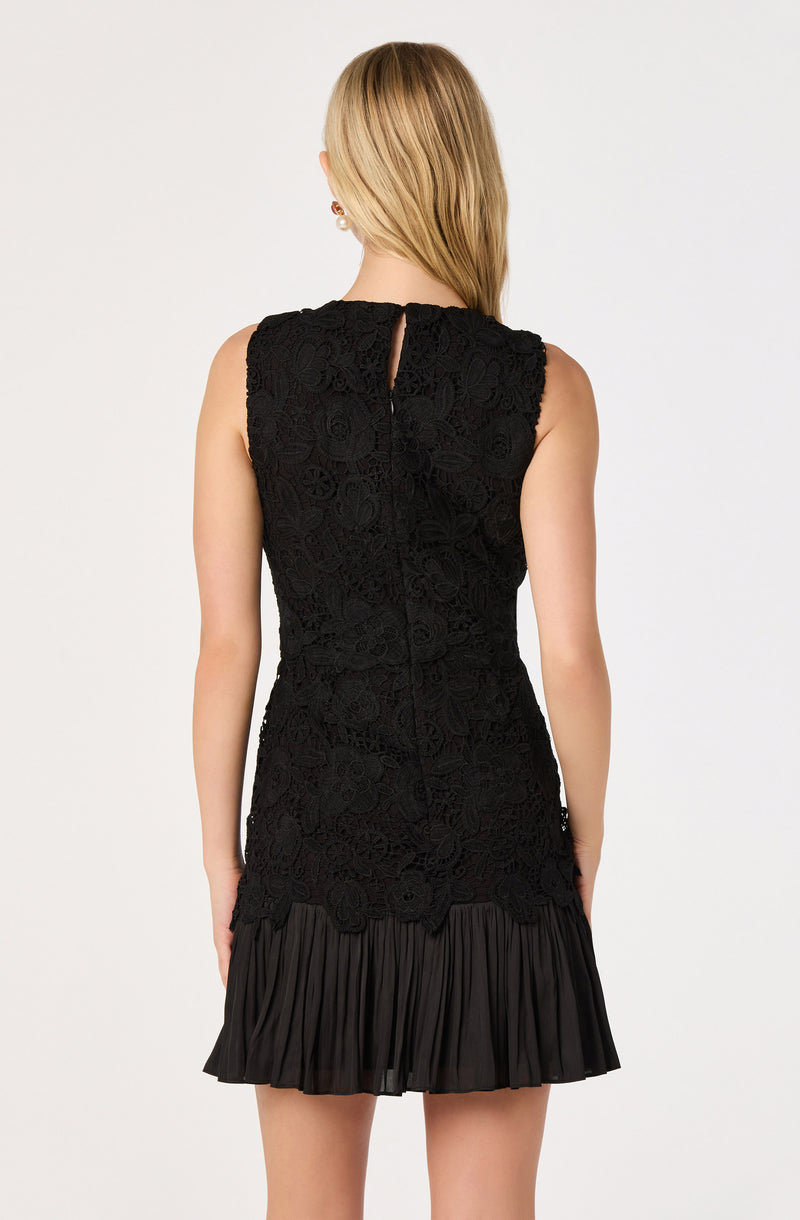 Black sleeveless dress with lace bodice and pleated hem.
