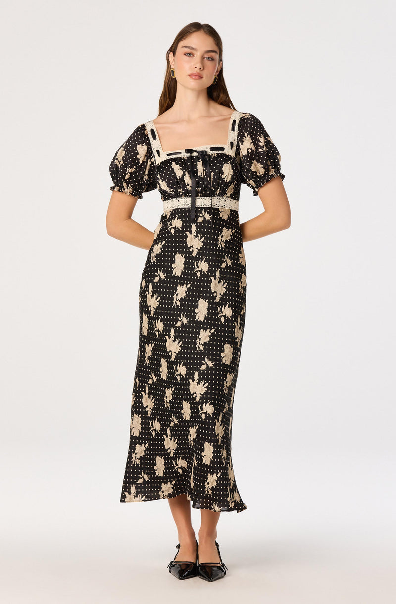 Black dress with beige floral pattern, puff sleeves, square neckline, and lace accents.