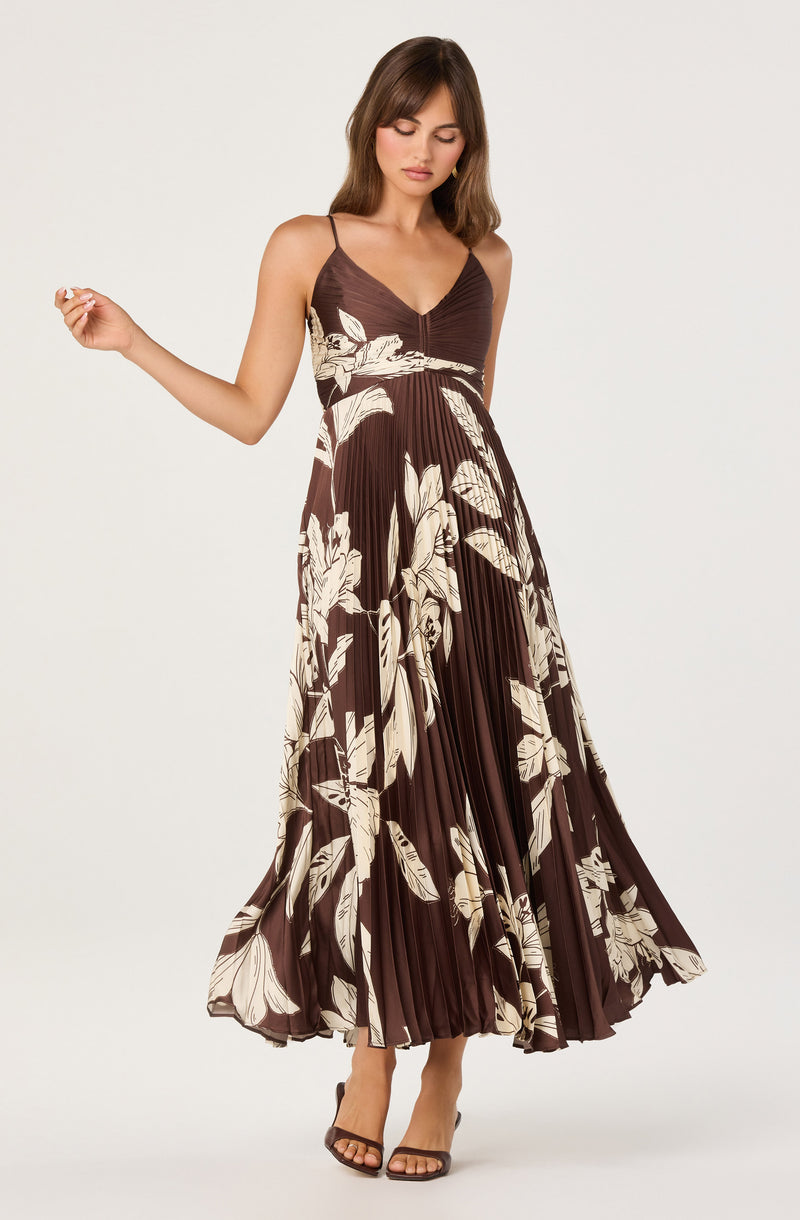 Brown spaghetti strap dress with white floral print and pleated skirt.