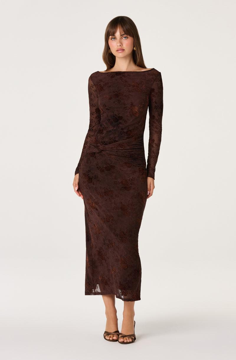 Woman in a long, dark brown, textured, fitted dress with long sleeves.