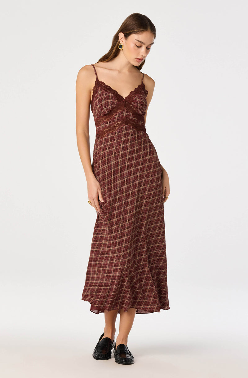 Woman wearing a burgundy plaid slip dress with lace details and spaghetti straps.