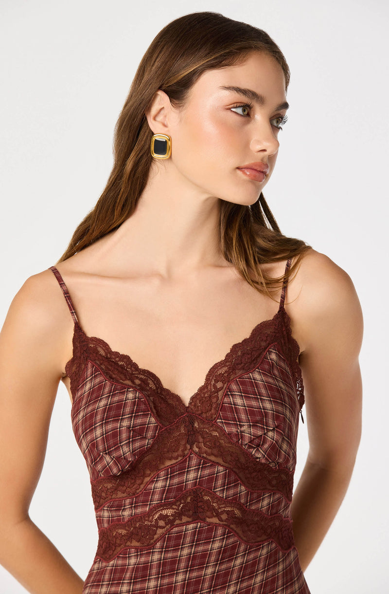 Woman wearing a plaid slip with lace trim and spaghetti straps.