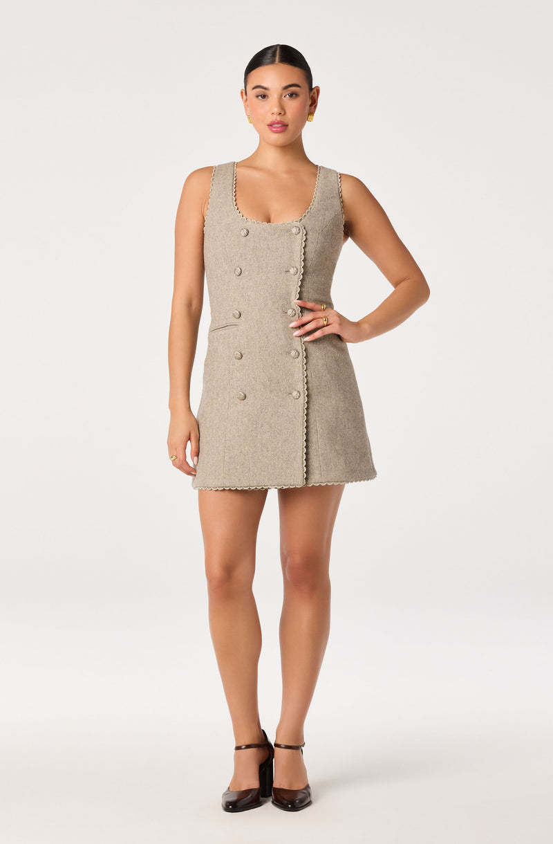 Beige sleeveless knit dress with double-breasted buttons and scalloped edges.
