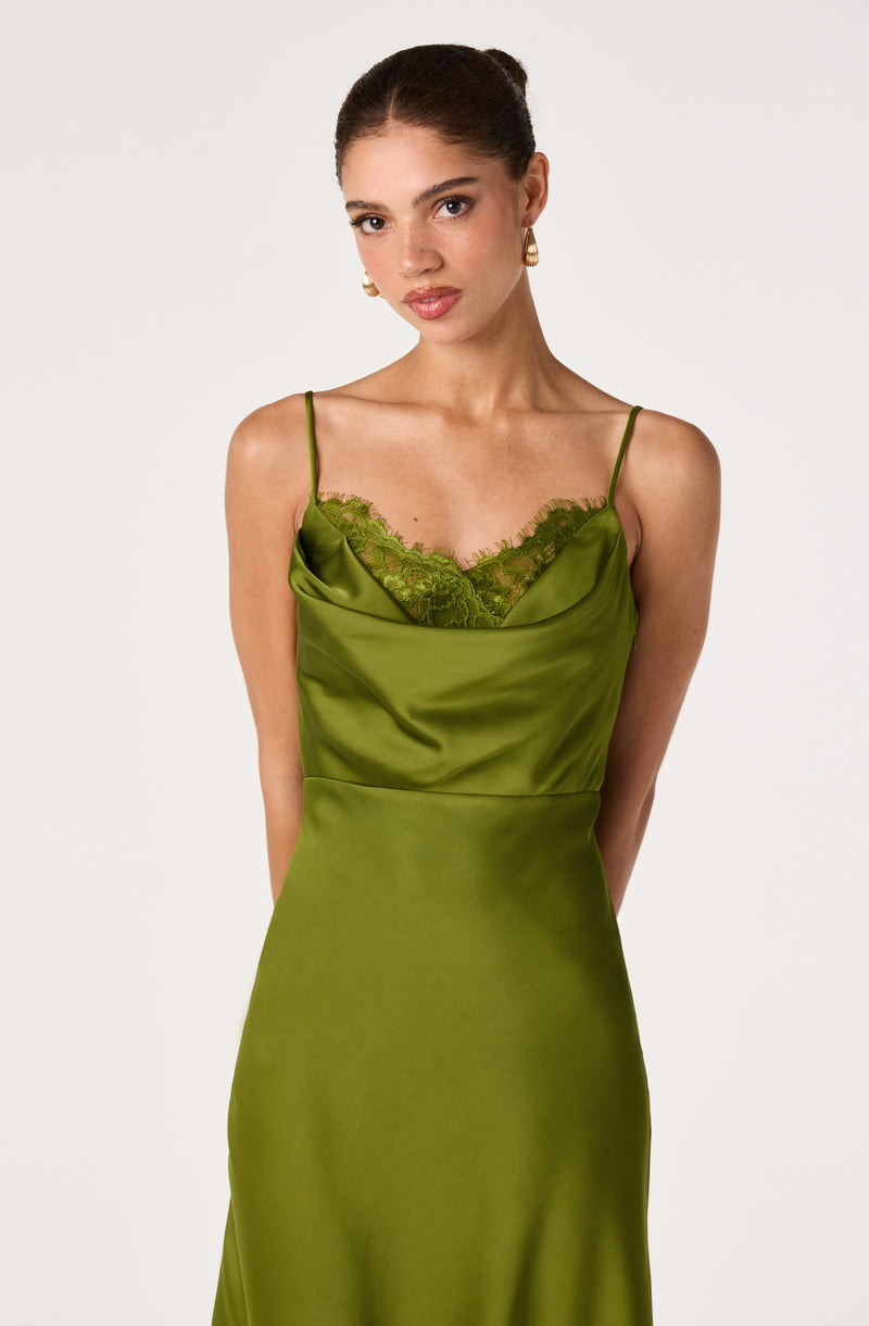 Girl in a green satin slip dress with spaghetti straps and lace detail at the neckline.