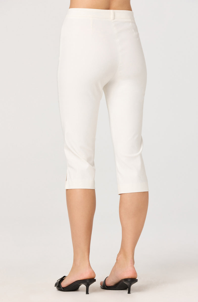 White cropped pants with a back zipper, worn with black heeled sandals.