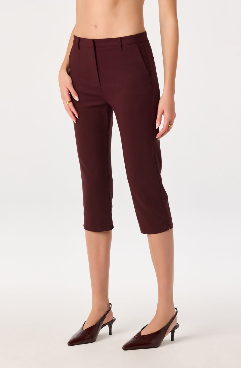 Woman wearing burgundy cropped dress pants and matching burgundy pointed-toe heels.