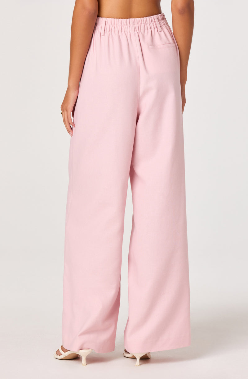 Woman in light pink wide-leg pants with an elastic waistband.