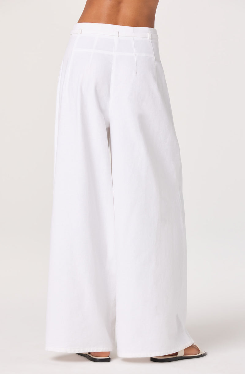White high-waisted wide-leg pants with belt loops, worn with sandals.