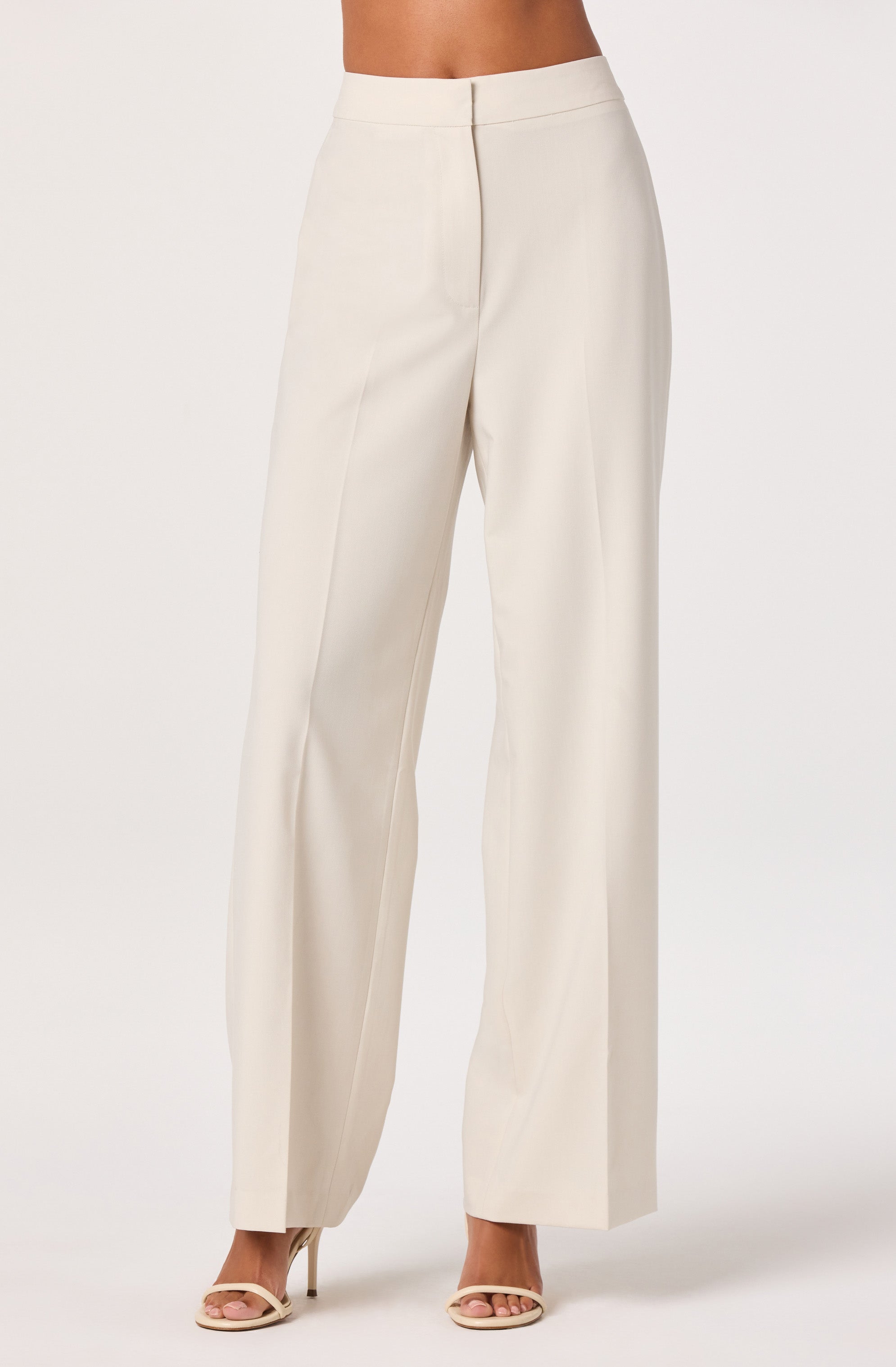 High-waisted cream wide-leg trousers with a front zipper and pleats.