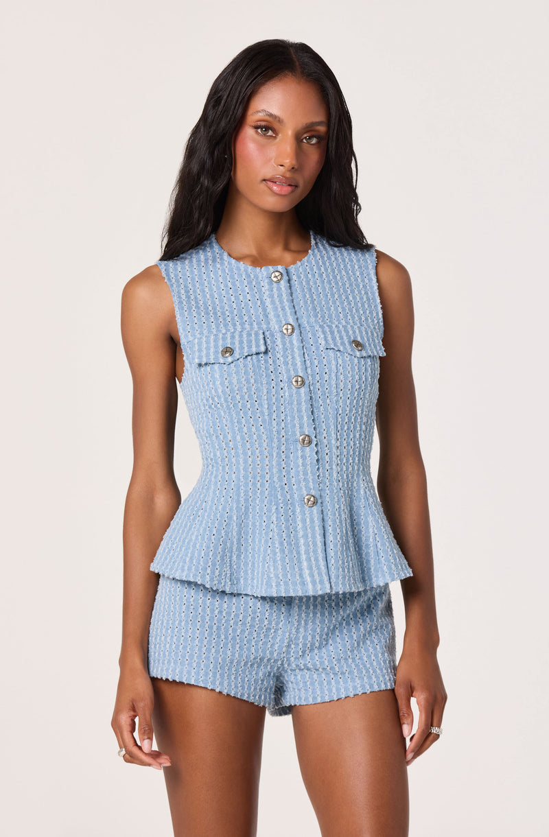 Model wears a light blue sleeveless textured top and matching shorts.