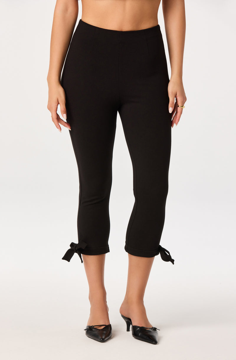Black cropped pants with side stripes and tied bows at the hem.