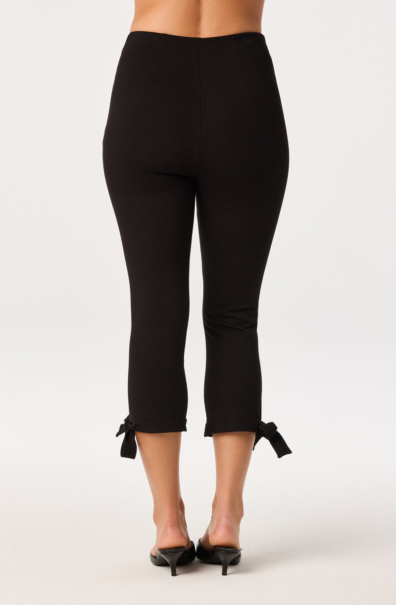 Black cropped pants with bow ties at the ankle, fitted style.