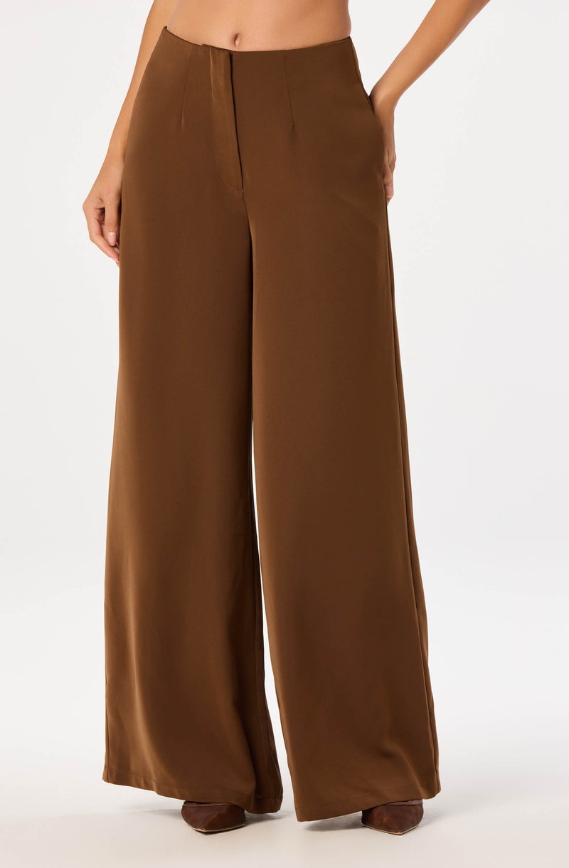 Brown high-waisted, wide-leg satin trousers with front pleats.